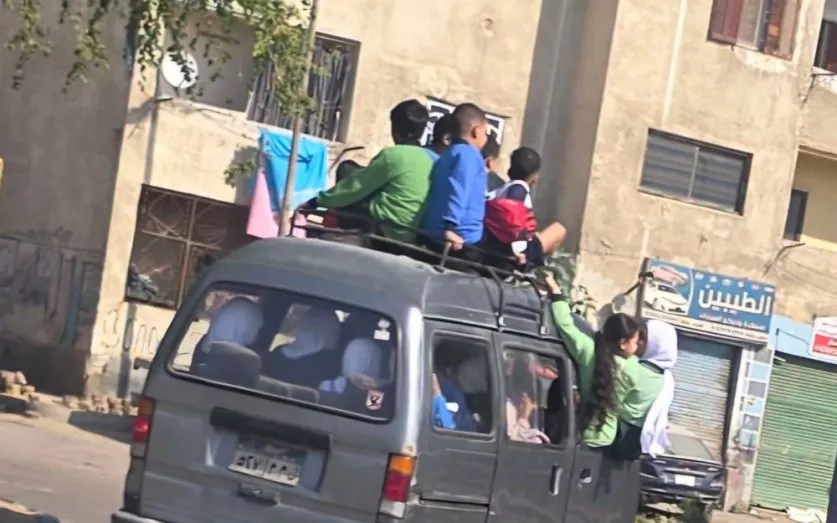 أطفال فوق سقف سيارة سوزوكي وعلى جوانبها في مدينة النهضة